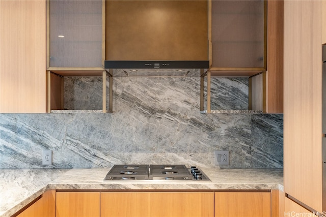 kitchen with tasteful backsplash, range hood, and stainless steel gas cooktop