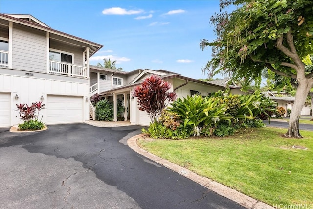 view of front of house featuring a balcony and a front yard