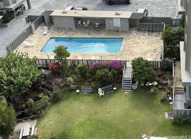 pool with stairs, a patio area, a lawn, and fence