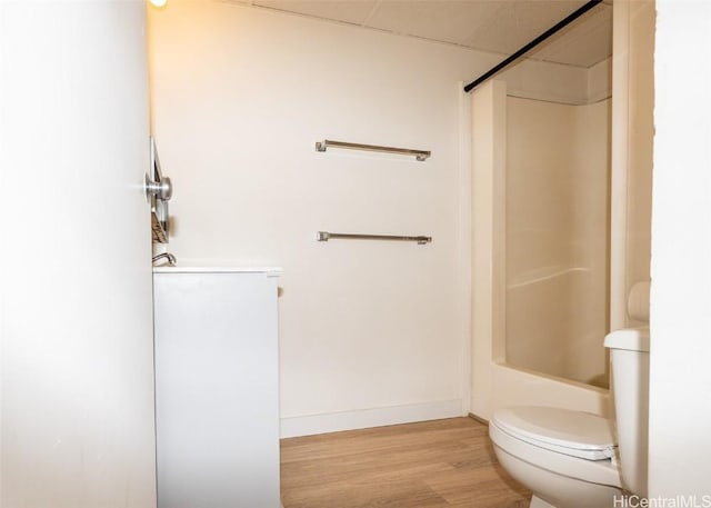 bathroom featuring wood finished floors, toilet, and baseboards