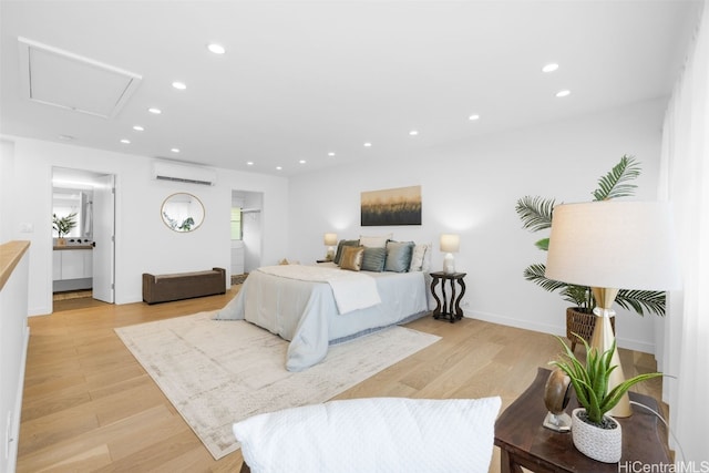 bedroom with light hardwood / wood-style floors and an AC wall unit