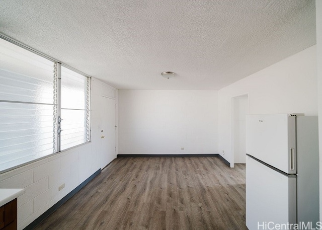 unfurnished room featuring hardwood / wood-style floors and a textured ceiling