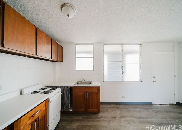 kitchen featuring electric range, sink, a textured ceiling, and light wood-type flooring