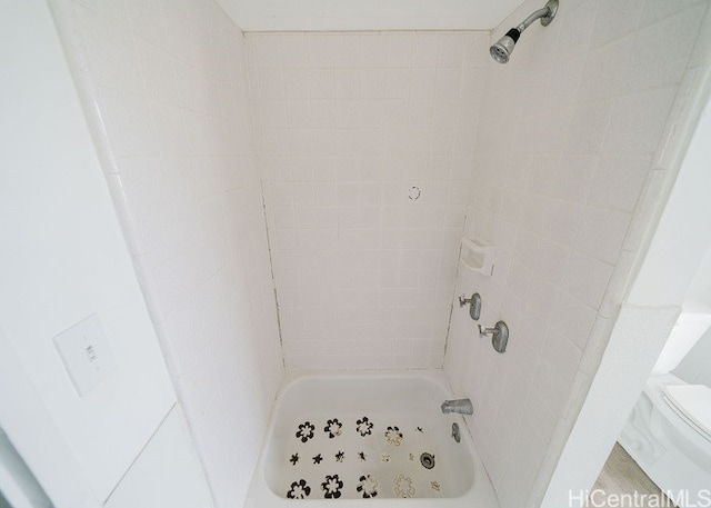 bathroom featuring toilet and a tile shower