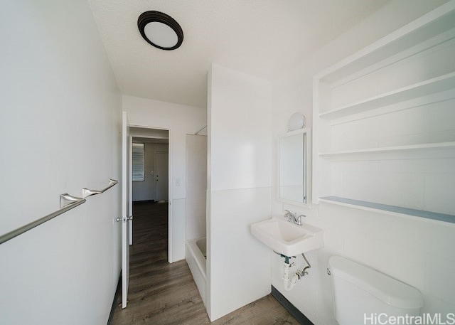 full bathroom featuring plus walk in shower, wood-type flooring, toilet, and sink