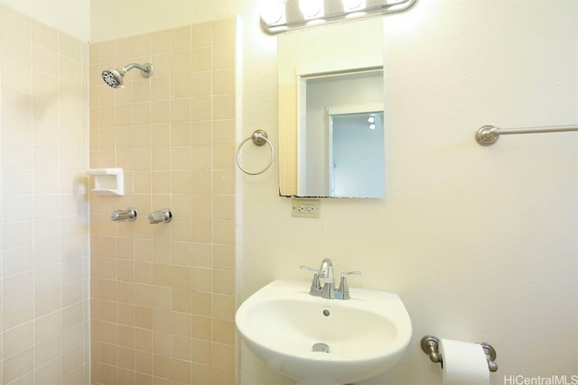 bathroom with a tile shower and sink