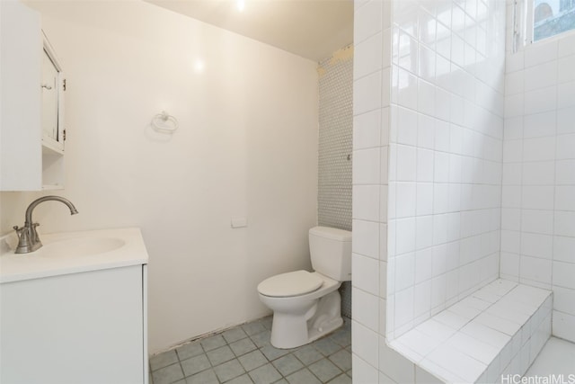 bathroom with toilet, vanity, and tile patterned floors