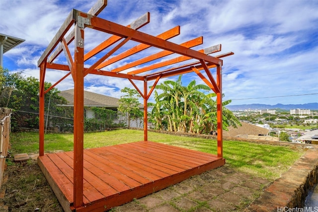 wooden terrace with a pergola, a mountain view, and a yard