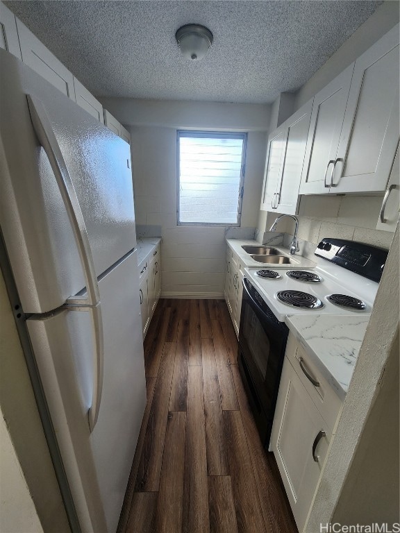 kitchen with white appliances, dark wood-type flooring, white cabinets, sink, and light stone countertops