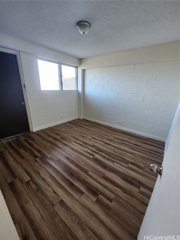 unfurnished room featuring a textured ceiling and dark wood-type flooring