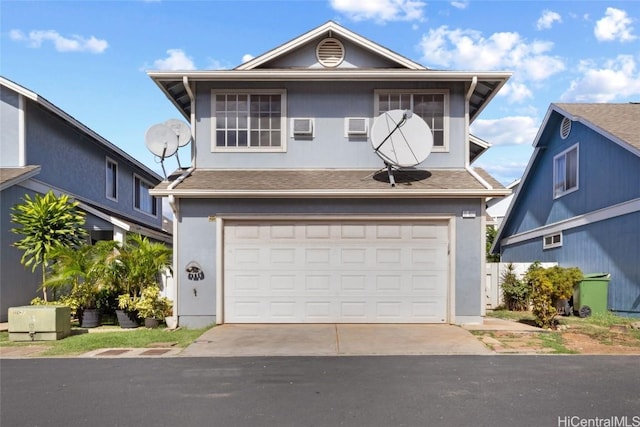 view of property with a garage and a wall mounted air conditioner