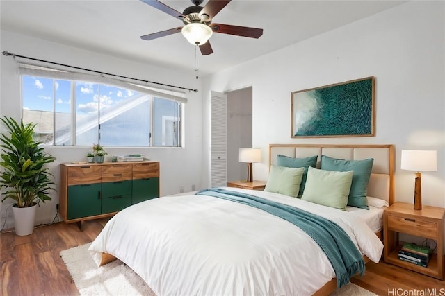 bedroom with ceiling fan, dark hardwood / wood-style floors, and a closet