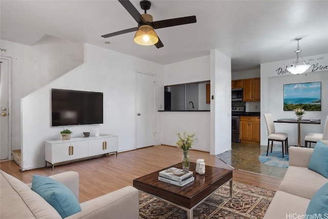 living room featuring wood-type flooring and ceiling fan