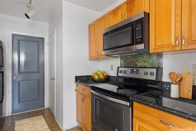 kitchen with tasteful backsplash, appliances with stainless steel finishes, and dark stone countertops