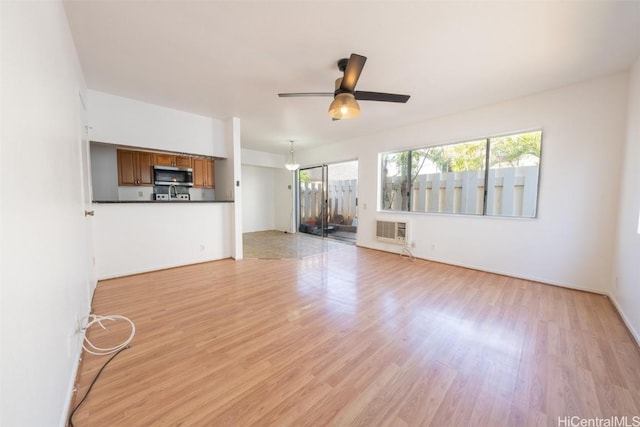 unfurnished living room with light hardwood / wood-style floors and ceiling fan