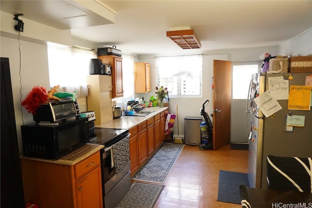 kitchen featuring light wood-type flooring, a wealth of natural light, and electric stove