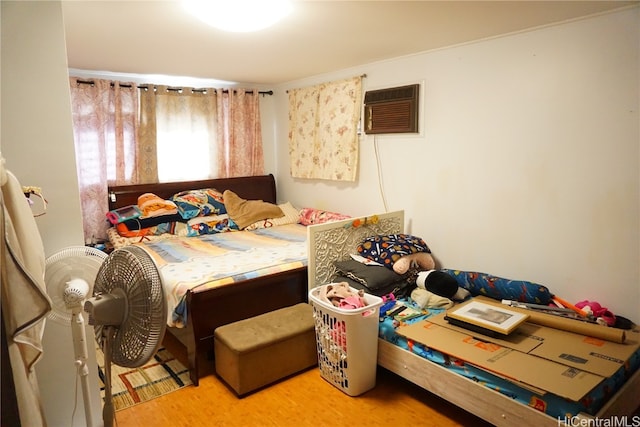 bedroom featuring light wood-type flooring and a wall unit AC