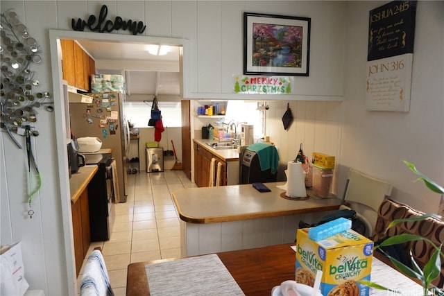 kitchen featuring light tile patterned floors, sink, and black / electric stove