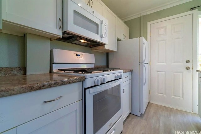 kitchen featuring dark stone countertops, light hardwood / wood-style floors, white appliances, white cabinets, and ornamental molding