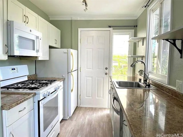 kitchen featuring white cabinetry, sink, light wood-type flooring, white appliances, and ornamental molding