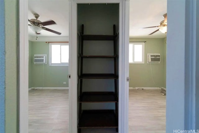 corridor with a wall mounted air conditioner and light wood-type flooring