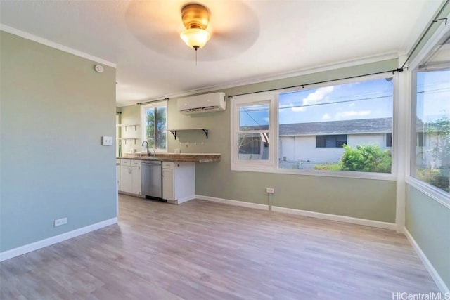 interior space featuring sink, ceiling fan, ornamental molding, a wall mounted AC, and light hardwood / wood-style floors