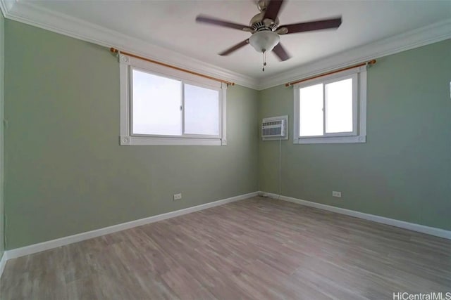 spare room featuring light hardwood / wood-style floors, a wall unit AC, and ornamental molding