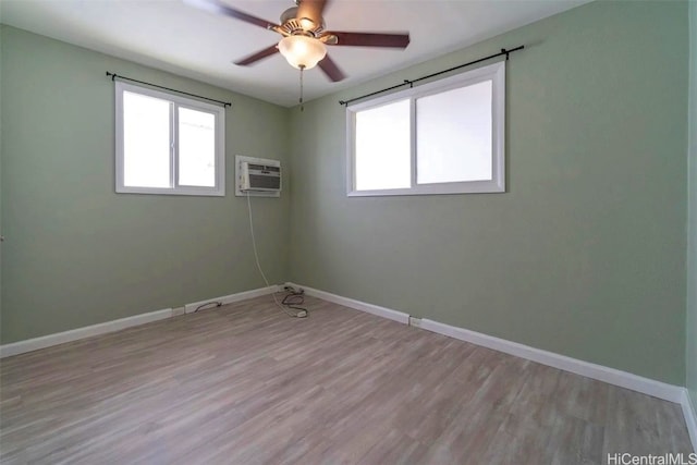 unfurnished room featuring ceiling fan, light hardwood / wood-style floors, and a wall unit AC