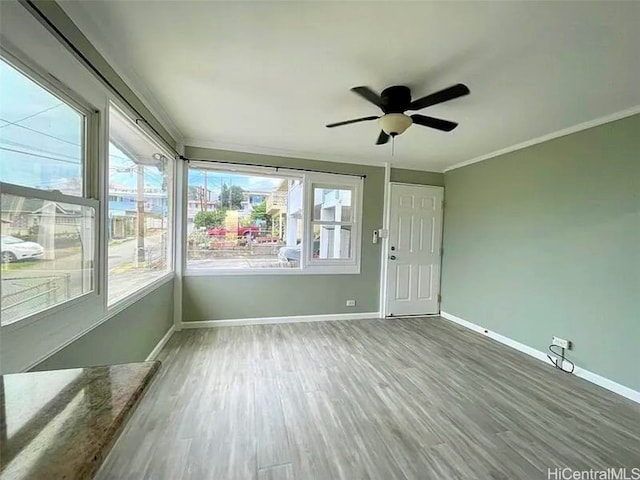 unfurnished sunroom featuring ceiling fan