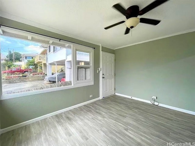 spare room featuring hardwood / wood-style flooring, ceiling fan, and crown molding