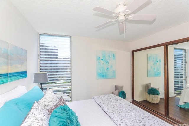 1848 Kahakai Dr Unit 1904, Honolulu, HI 96814 - bedroom featuring wood finished floors, ceiling fan, and a textured ceiling