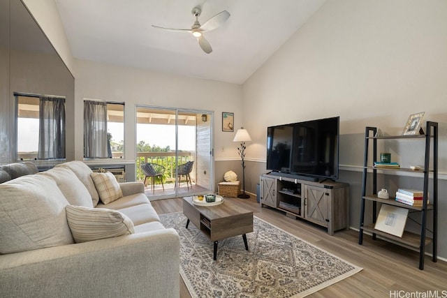 living room with high vaulted ceiling, a ceiling fan, and wood finished floors