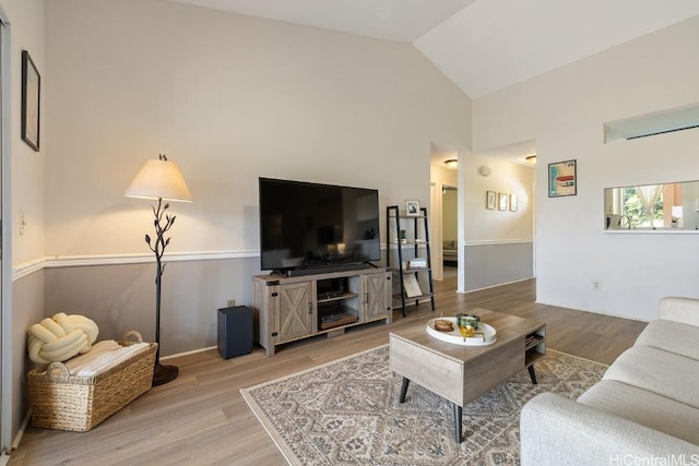 living area featuring vaulted ceiling and wood finished floors