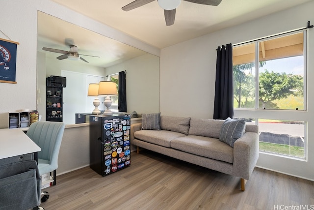 living area with a ceiling fan and wood finished floors