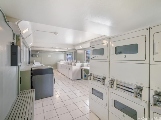 clothes washing area featuring washing machine and clothes dryer, stacked washing maching and dryer, and light tile patterned flooring