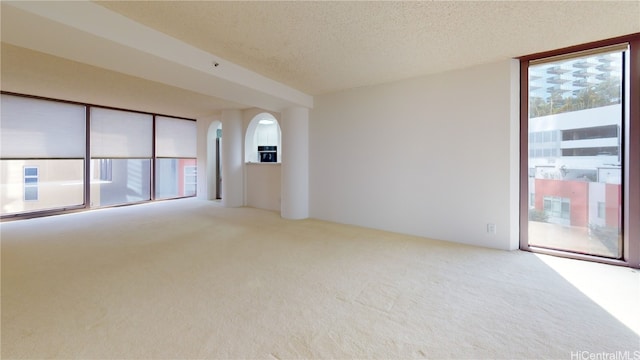 carpeted empty room featuring a textured ceiling