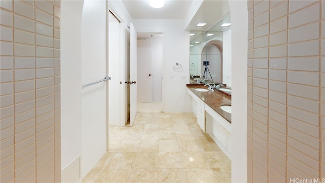 bathroom with vanity and tile walls