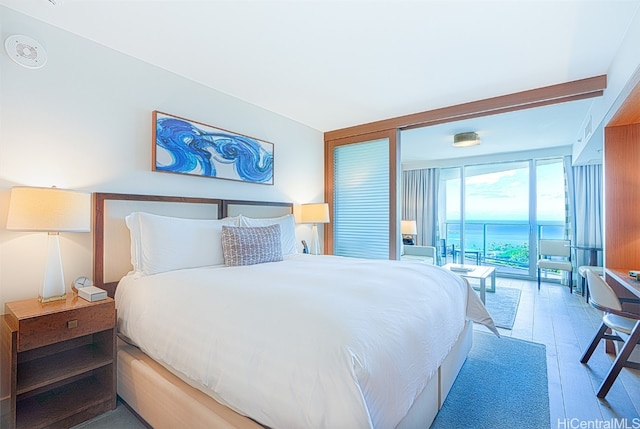 bedroom featuring light hardwood / wood-style floors and a wall of windows