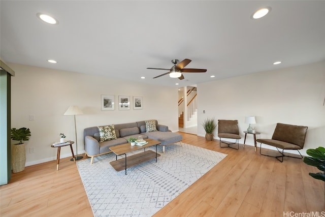 living room with ceiling fan and light hardwood / wood-style flooring