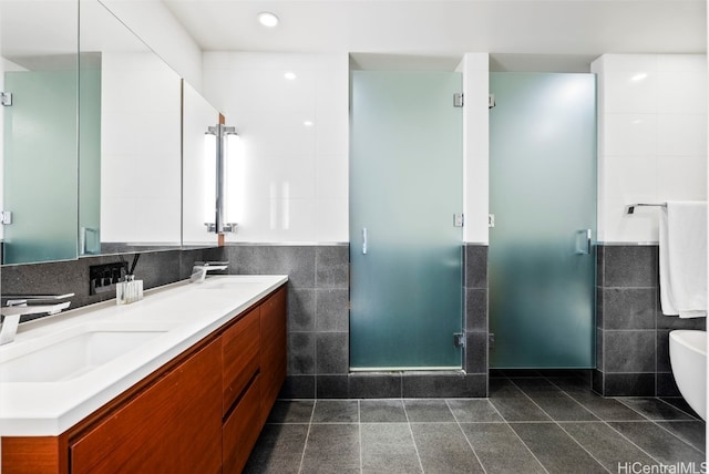 bathroom with tile patterned flooring, vanity, tile walls, and independent shower and bath