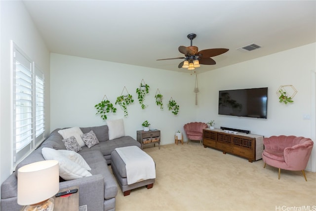 living room with visible vents, light carpet, and ceiling fan