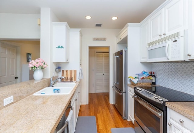 kitchen with visible vents, light countertops, appliances with stainless steel finishes, white cabinets, and a sink