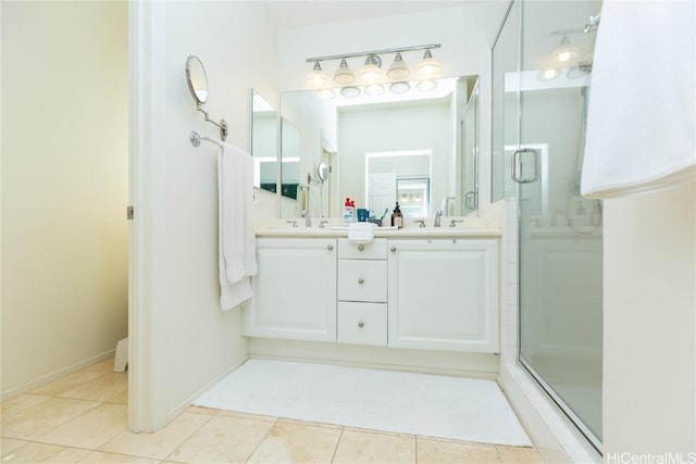 full bath with baseboards, double vanity, a sink, tile patterned flooring, and a shower stall