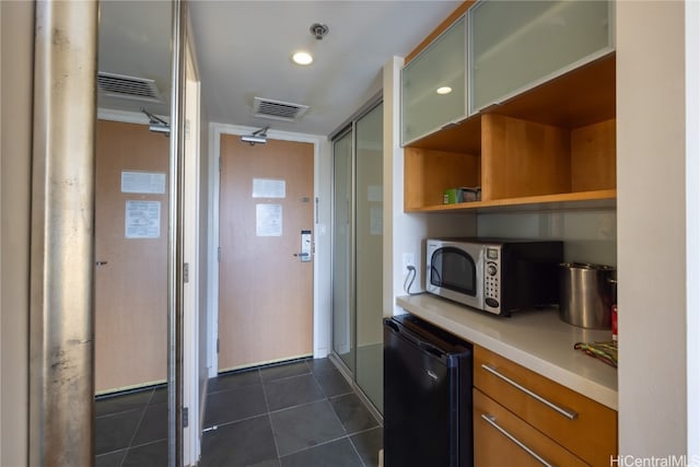 kitchen featuring black refrigerator and dark tile patterned flooring