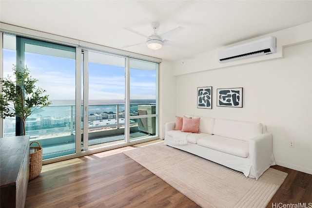 living room with a water view, a wall unit AC, a wealth of natural light, and hardwood / wood-style flooring