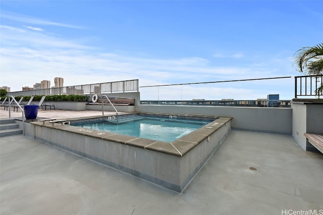 view of swimming pool with a hot tub