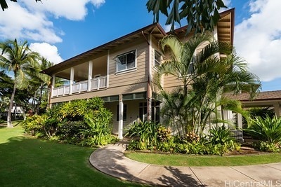 view of front facade featuring a balcony and a front lawn