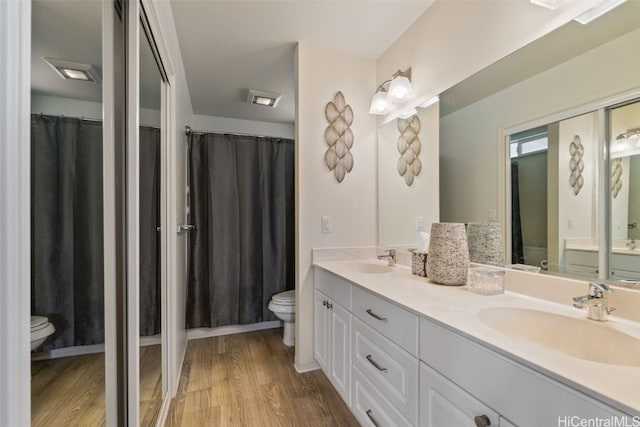 bathroom with hardwood / wood-style flooring, vanity, and toilet