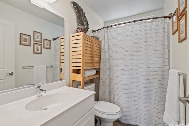 bathroom featuring a shower with shower curtain, vanity, and toilet