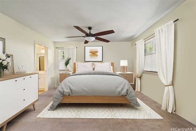 bedroom with light colored carpet, multiple windows, and ceiling fan